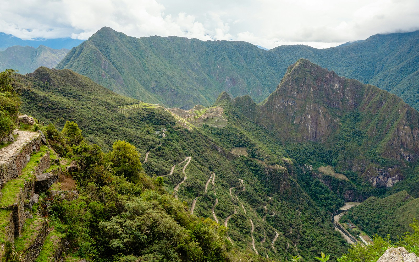 Machu Picchu terraces and winding road in the Andes Mountains, Peru.