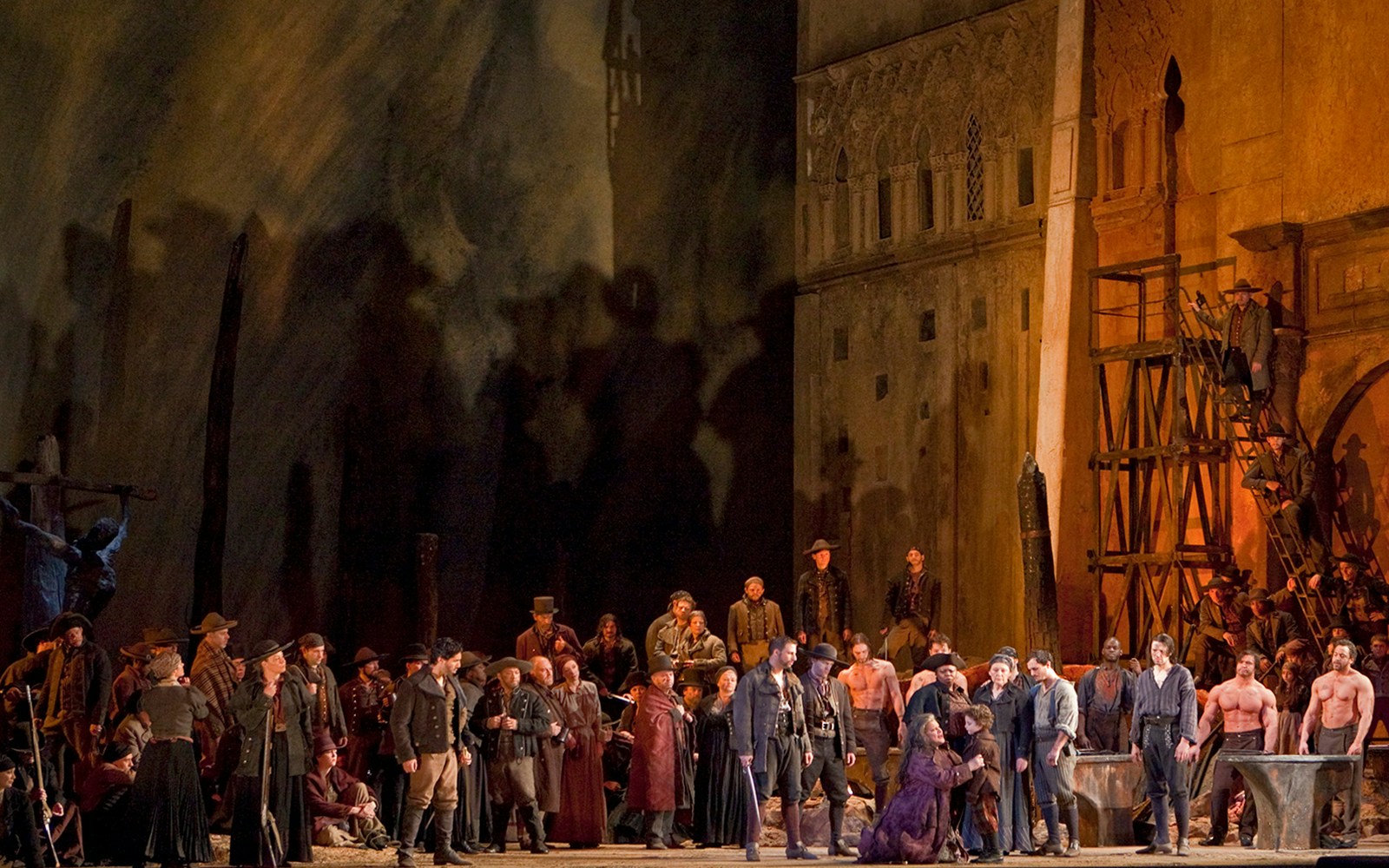 Opera performers on stage during Il Trovatore, featuring a dramatic medieval setting.