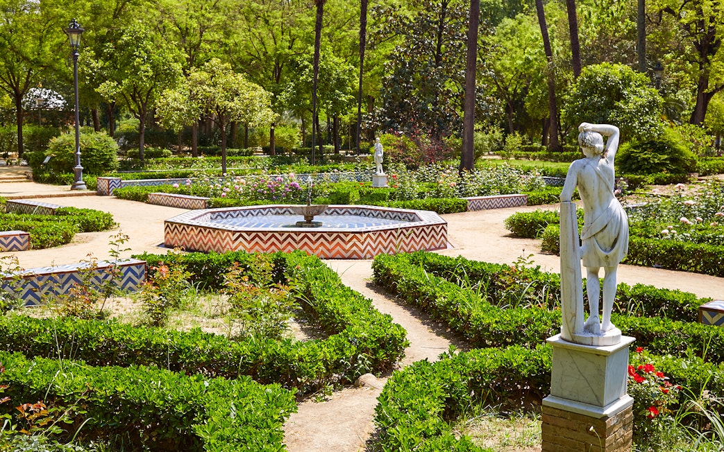 María Luisa Park garden with statue and fountain, Seville.