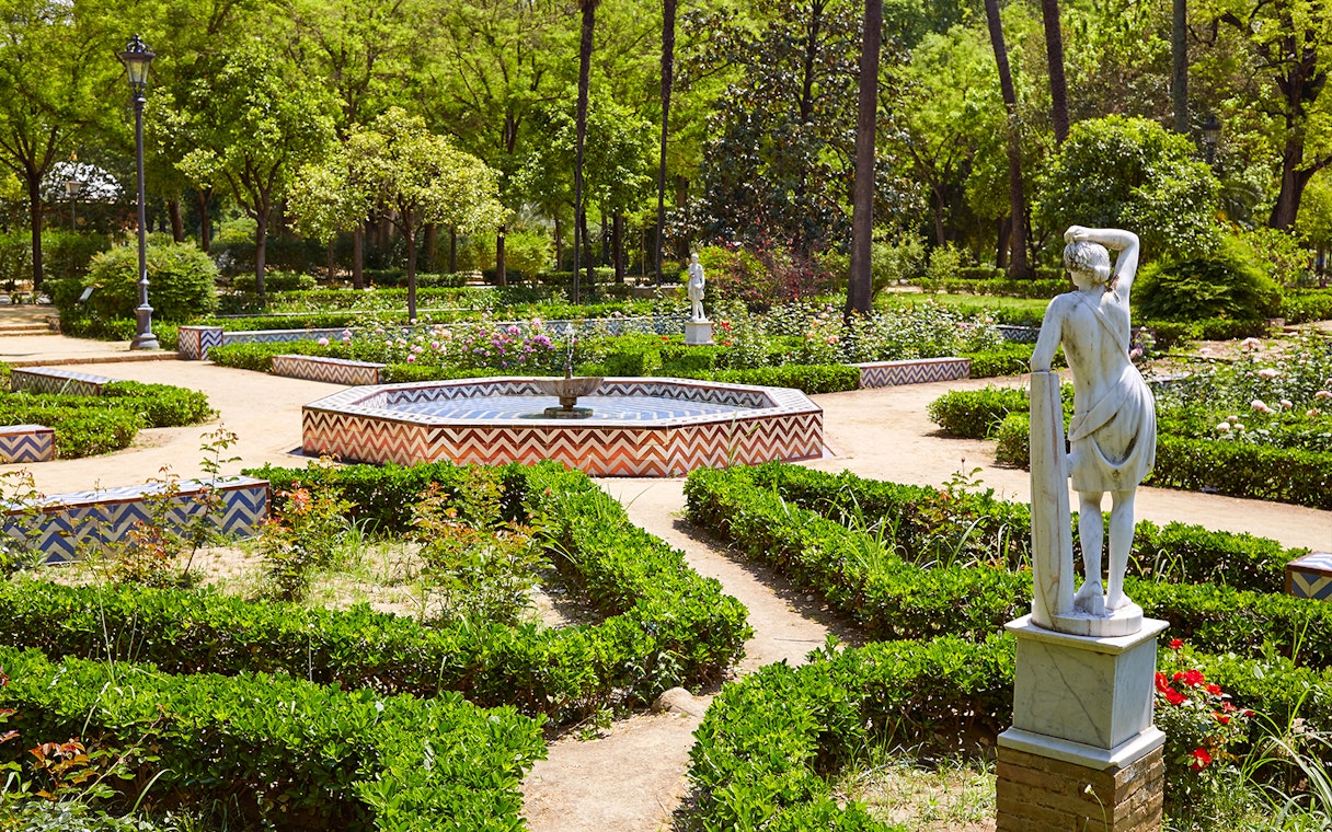 María Luisa Park garden with statue and fountain, Seville.