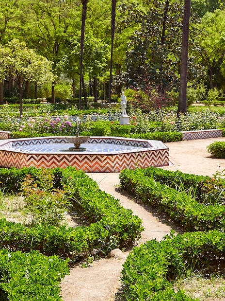 María Luisa Park garden with statue and fountain, Seville.