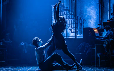 Actors performing a dramatic scene in Hadestown on West End stage.