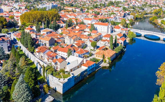 Trebinje old town with red-roofed buildings and Trebišnjica River, Bosnia and Herzegovina.