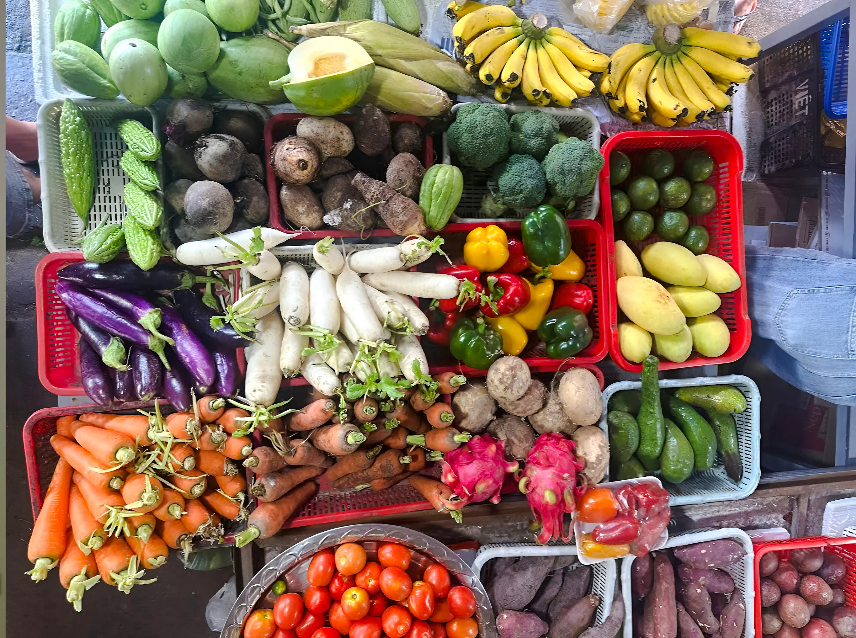 Fresh vegetables and fruits at a market in Hoi An, showcasing local produce for a cooking experience.