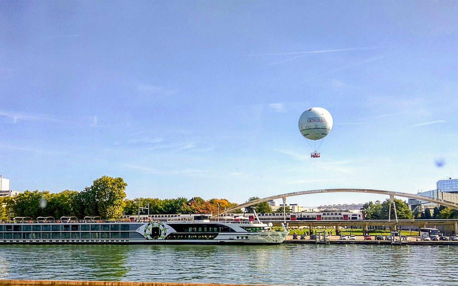 Hot air balloon over Seine River near bridge in Paris.