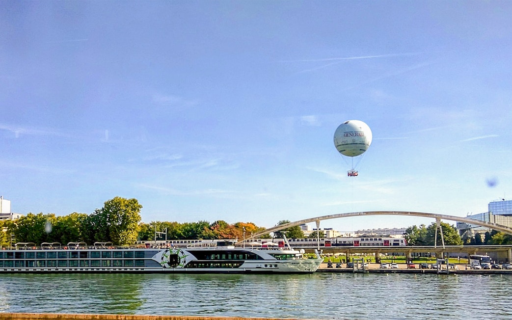 Hot air balloon over Seine River near bridge in Paris.