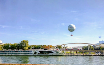 Hot air balloon over Seine River near bridge in Paris.