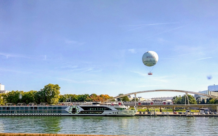 Hot air balloon over Seine River near bridge in Paris.