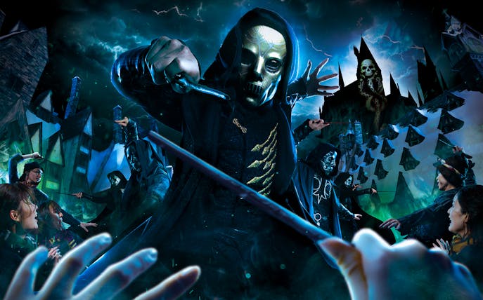 Masked figures with wands in a magical battle scene at a theme park attraction.
