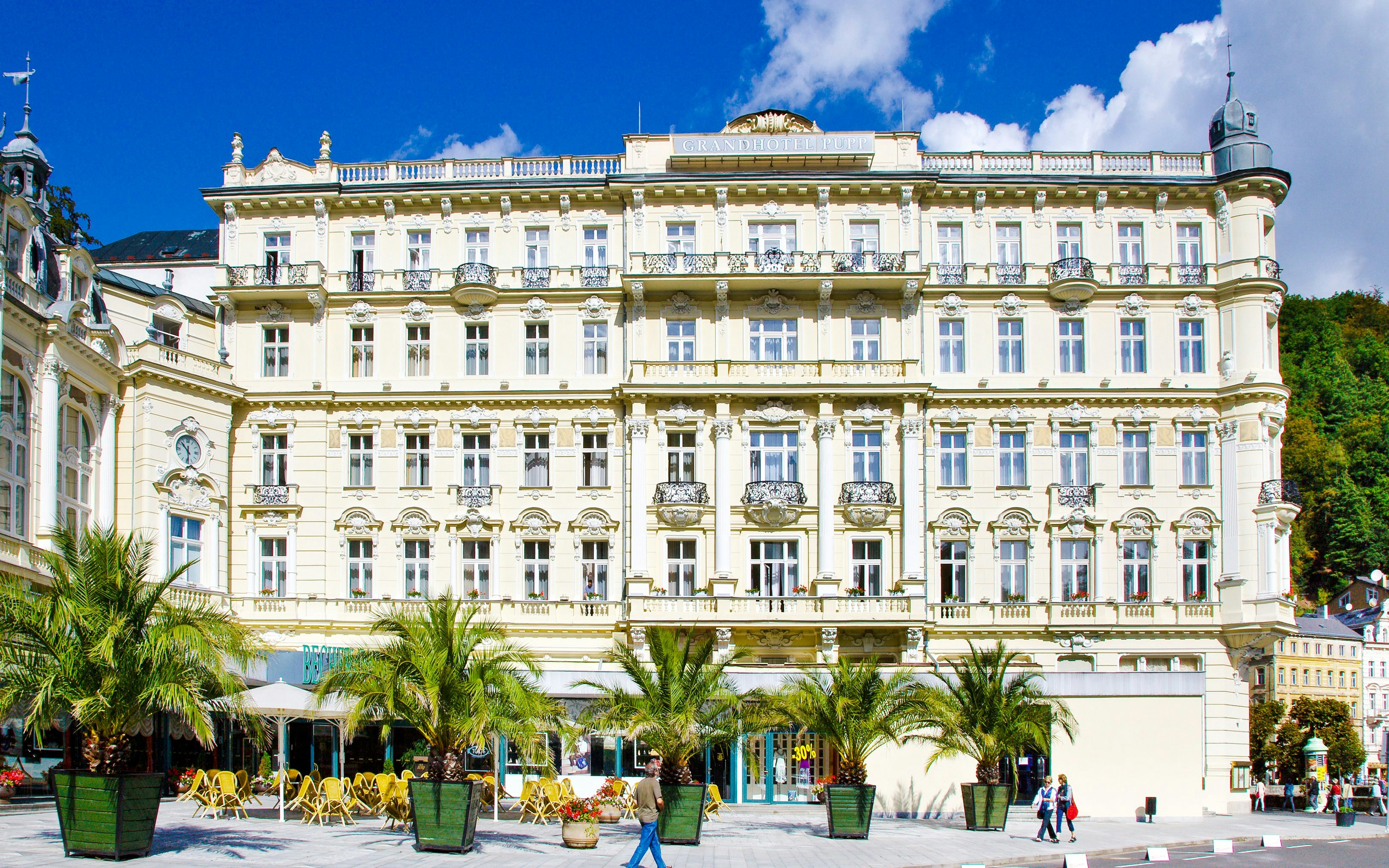 Pupp Grandhotel facade with palm trees in Karlovy Vary, Czech Republic.
