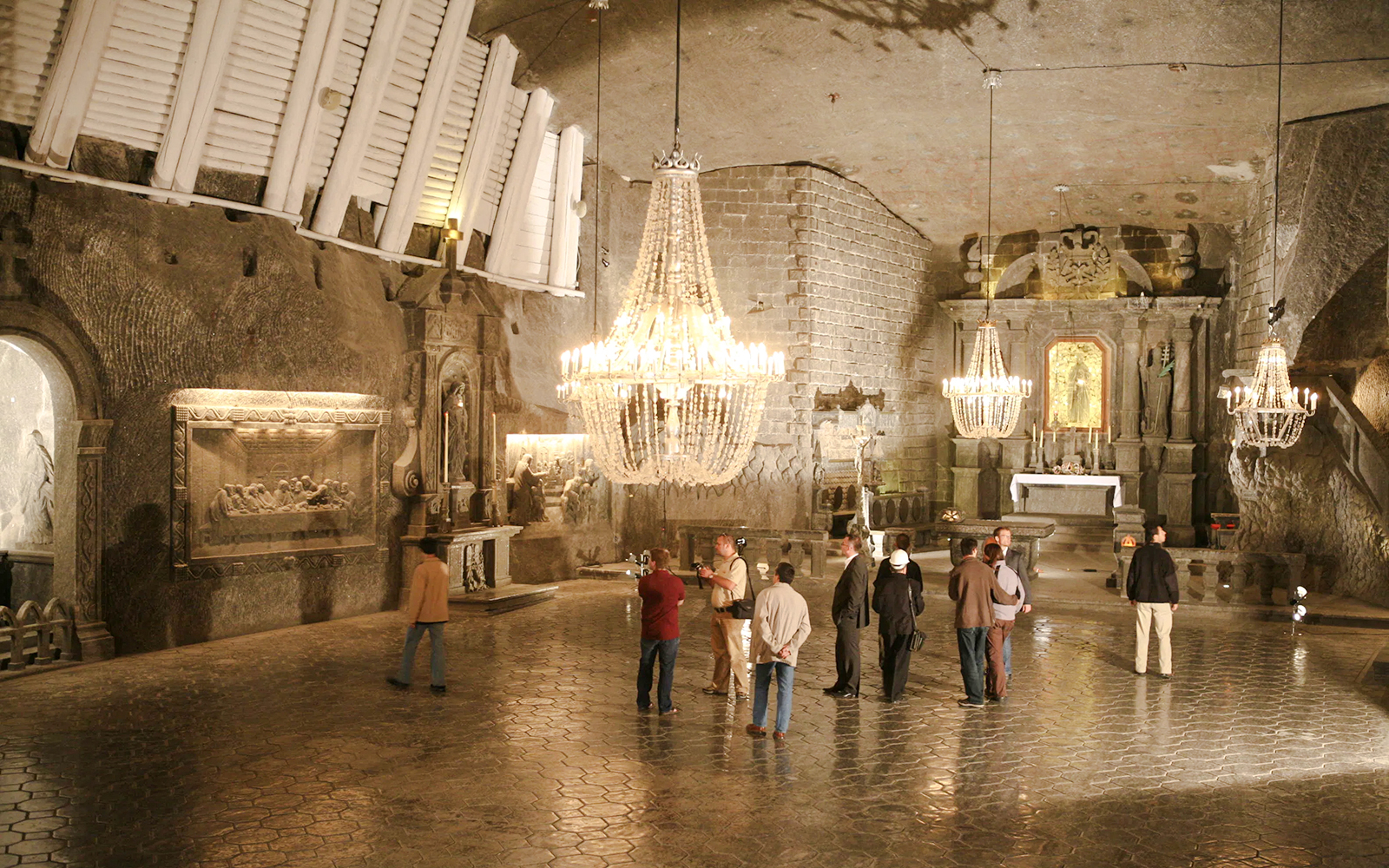 Guests exploring the ornate chapel inside Wieliczka Salt Mine, Poland.