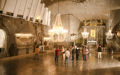 Guests exploring the ornate chapel inside Wieliczka Salt Mine, Poland.