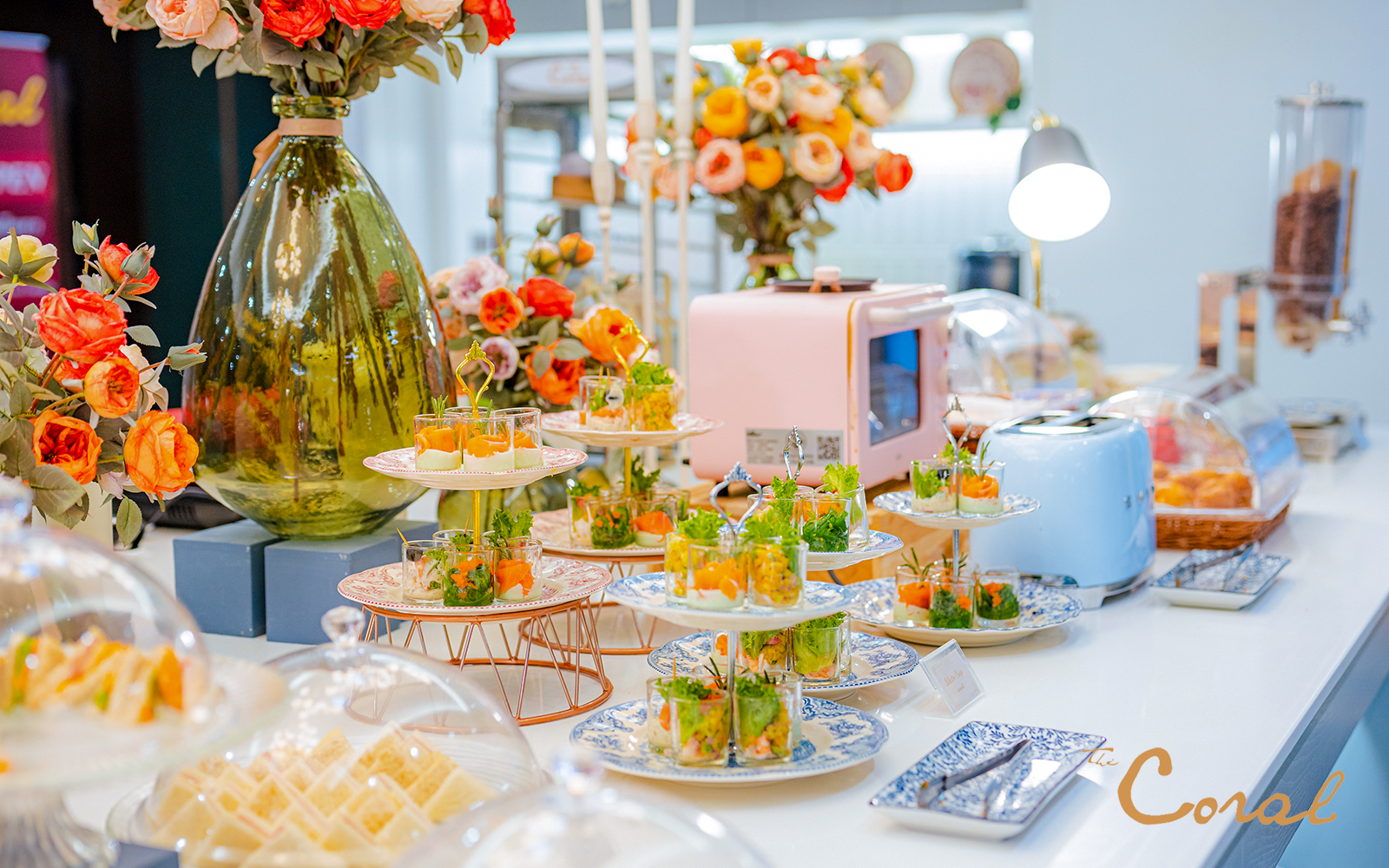 Buffet spread with appetizers and flowers at Coral Finest Business Class Lounge, Bangkok airport, Thailand.