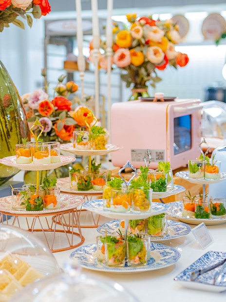 Buffet spread with appetizers and flowers at Coral Finest Business Class Lounge, Bangkok airport, Thailand.