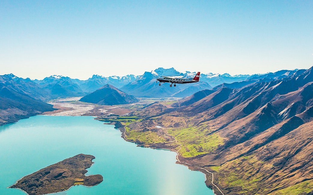 Plane flying over a lake with mountains during a scenic flight to Milford Sound.