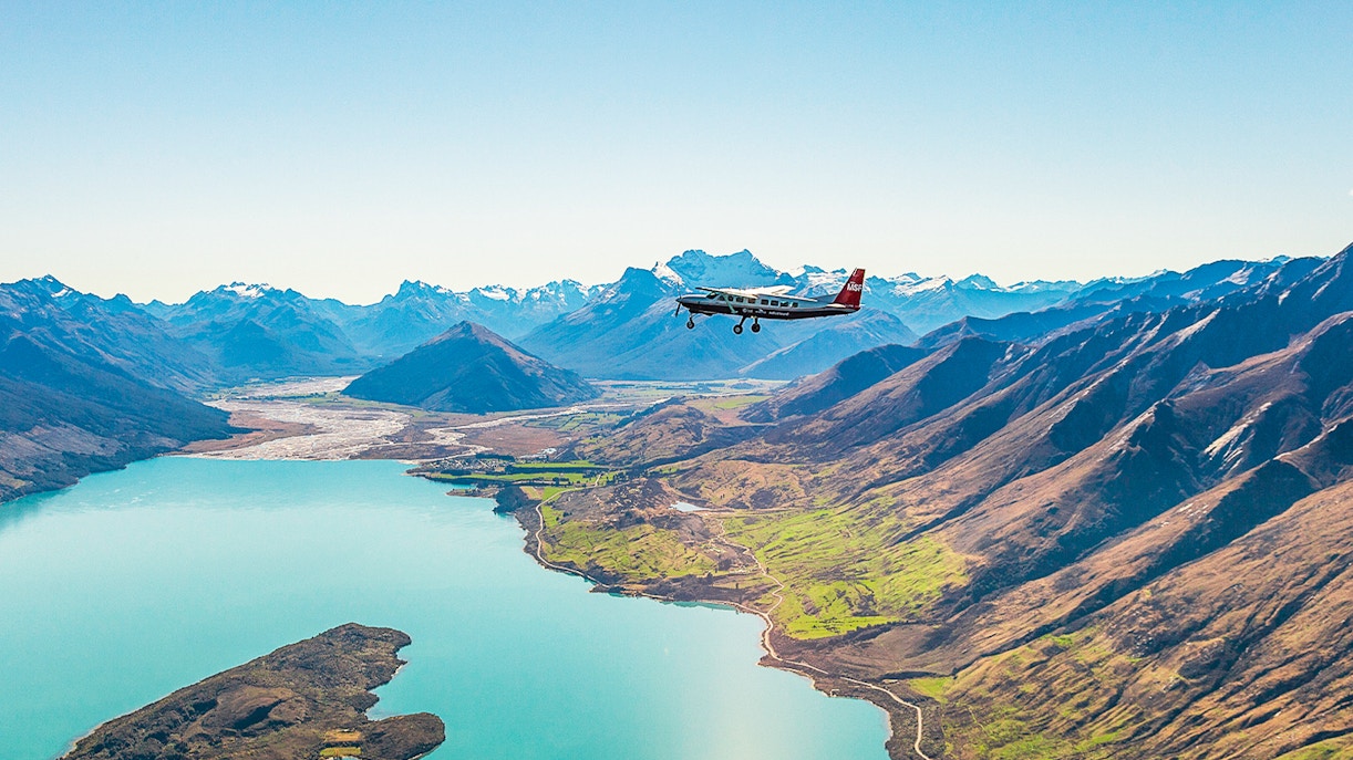 Plane flying over a lake with mountains during a scenic flight to Milford Sound.
