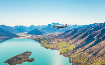 Plane flying over a lake with mountains during a scenic flight to Milford Sound.