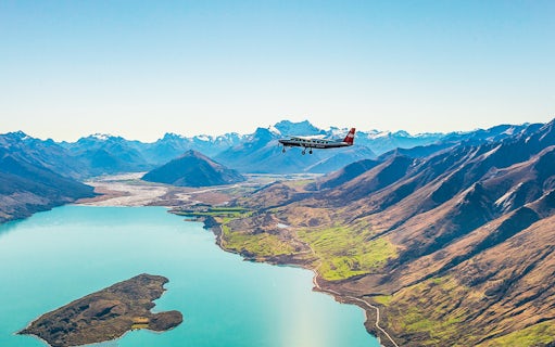 Plane flying over a lake with mountains during a scenic flight to Milford Sound.