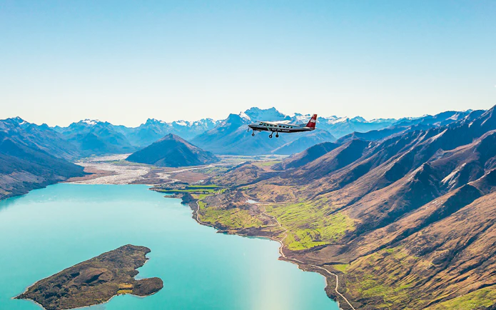 Plane flying over a lake with mountains during a scenic flight to Milford Sound.