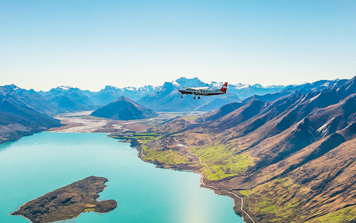 Plane flying over a lake with mountains during a scenic flight to Milford Sound.