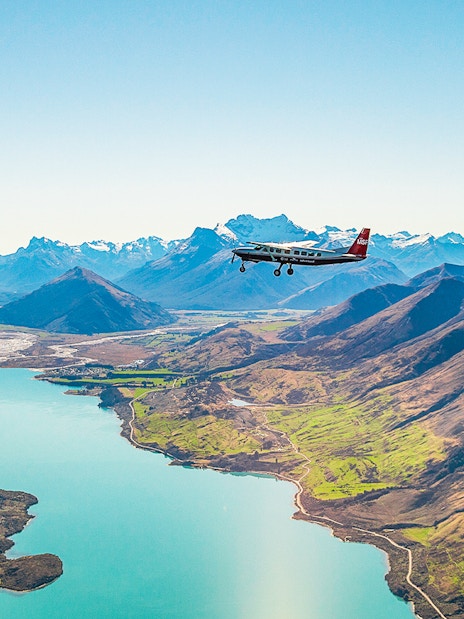 Plane flying over a lake with mountains during a scenic flight to Milford Sound.