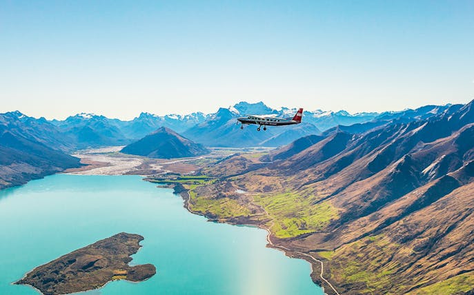 Plane flying over a lake with mountains during a scenic flight to Milford Sound.
