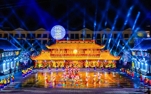 Performers in traditional attire at The Quintessence of Vietnam Show, vibrant stage lighting.