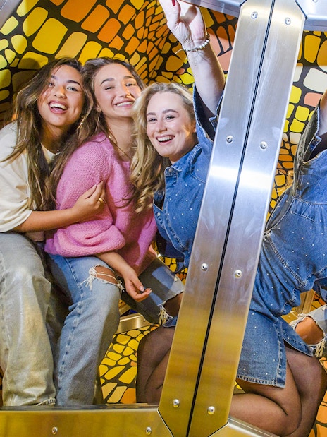 Group of friends enjoying The TUBE experience with colorful mosaic walls.
