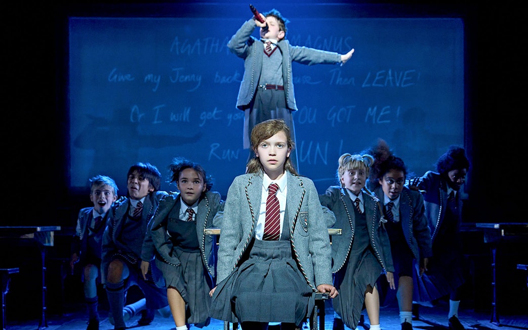 Children performing a scene from Matilda The Musical on stage.