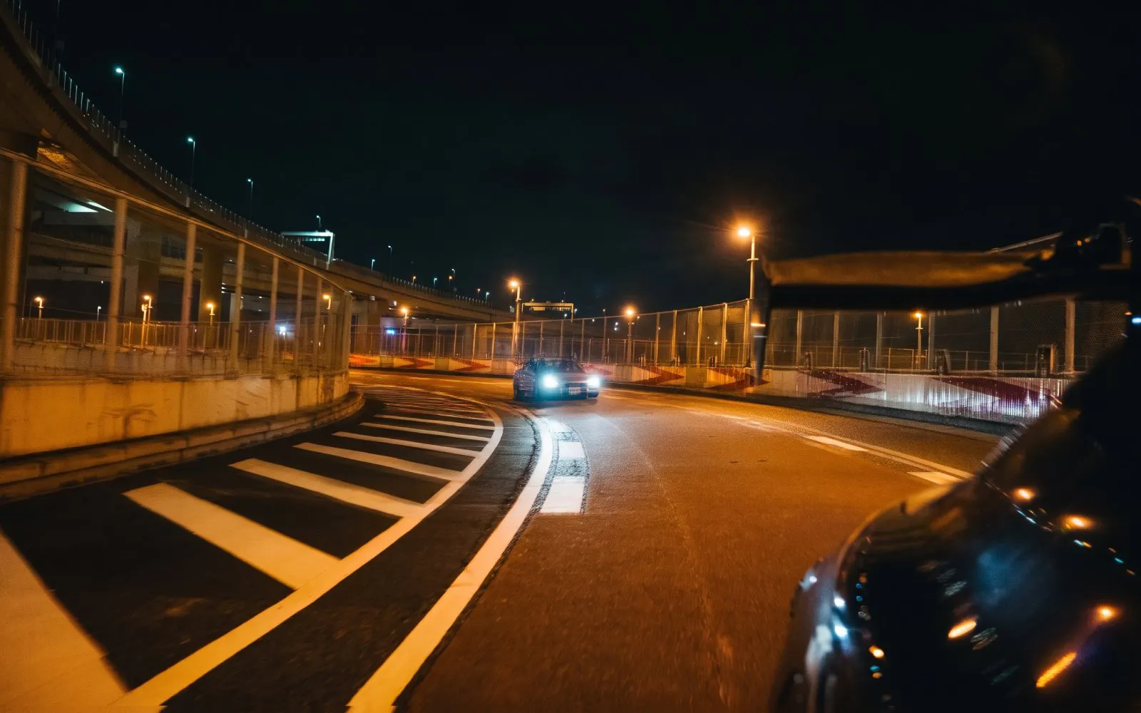 Car drifting on Tokyo highway at night during Fast and Furious experience.