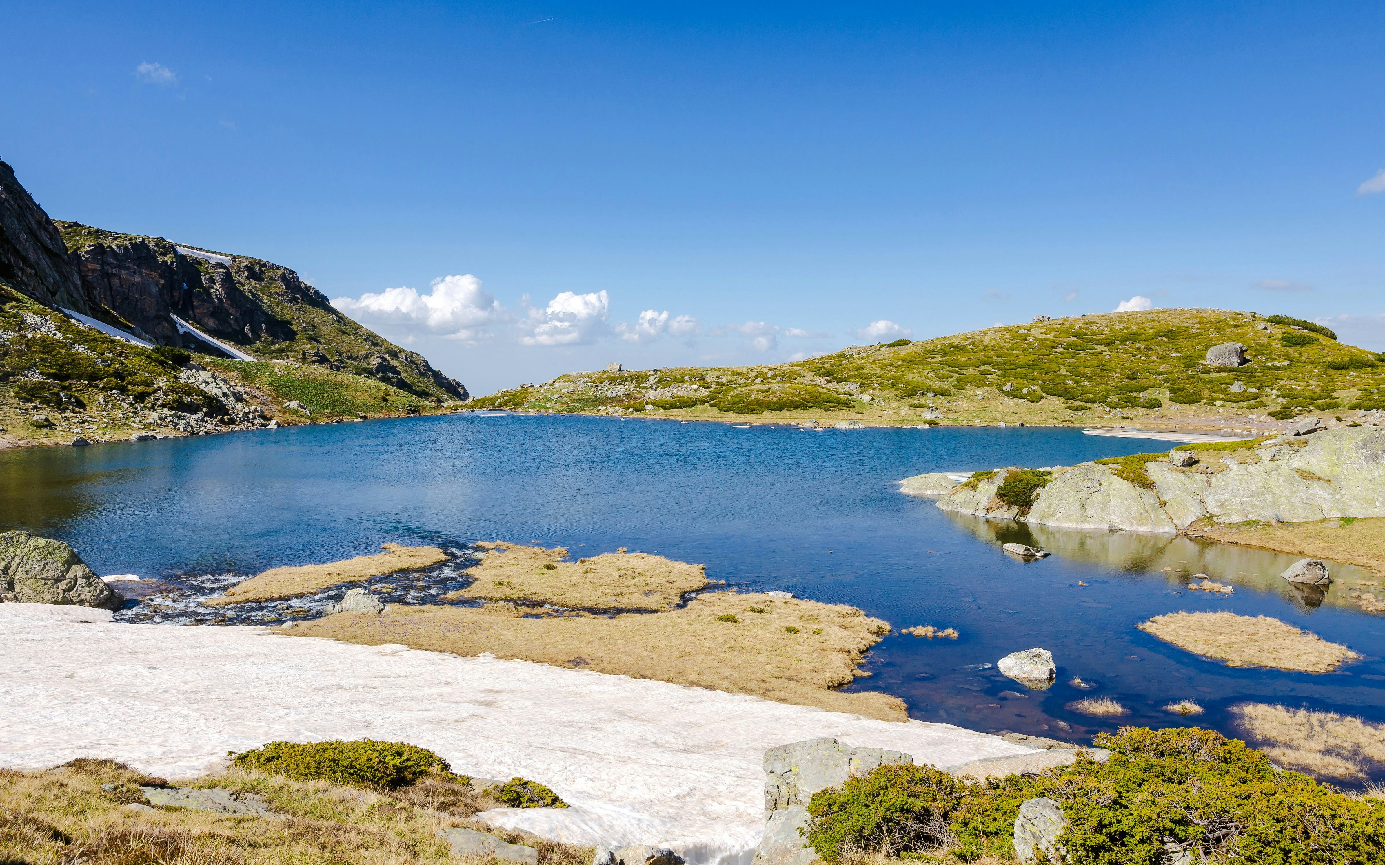 Trefoil Lake in Rila Mountains with clear blue water and surrounding rocky landscape.