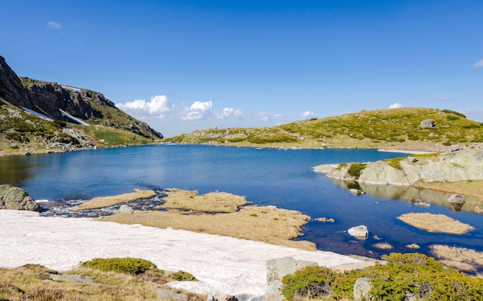 Trefoil Lake in Rila Mountains with clear blue water and surrounding rocky landscape.