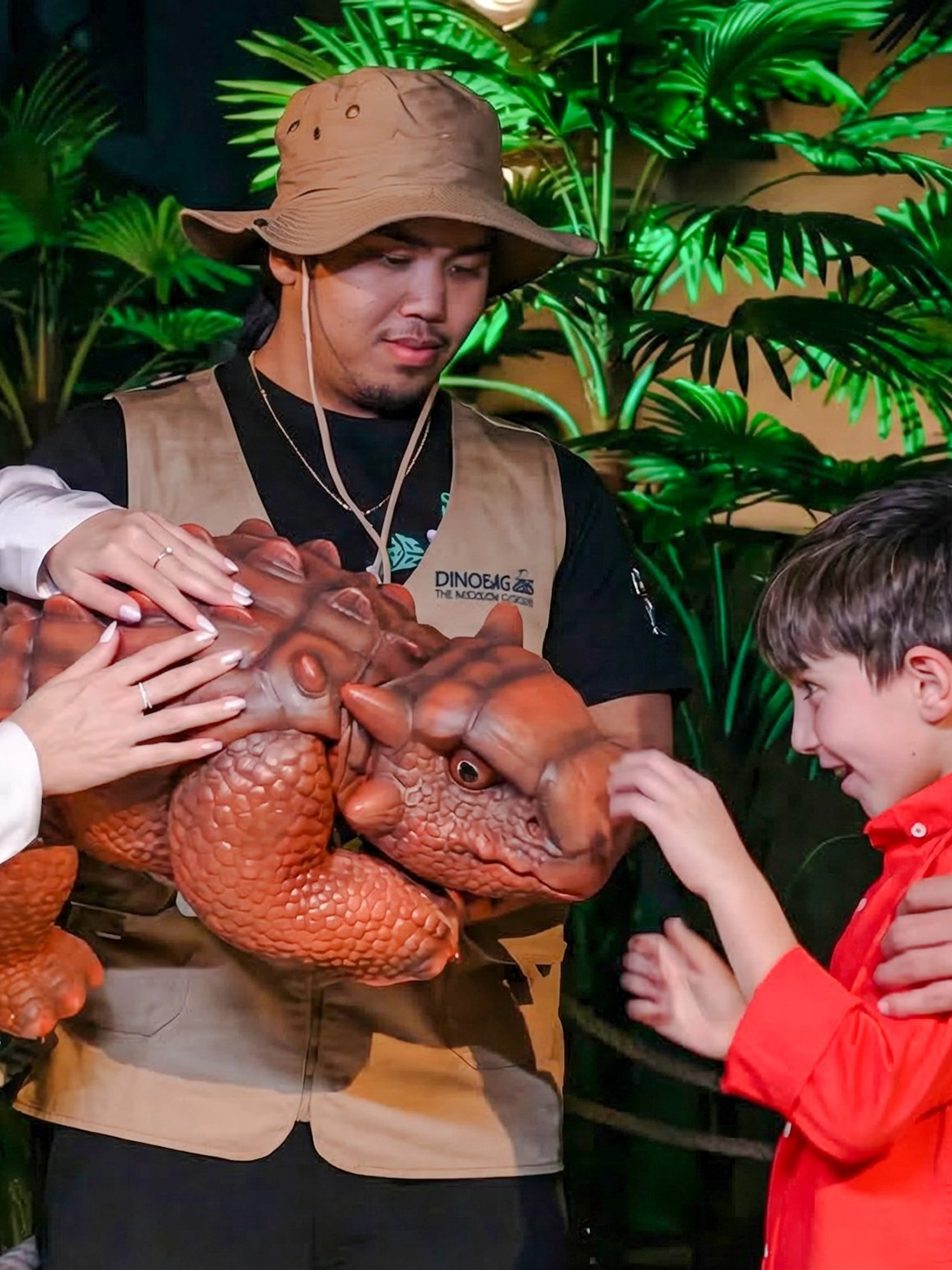 Visitors interacting with a dinosaur model at Dinosaurs: The Immersive Odyssey VR Experience.