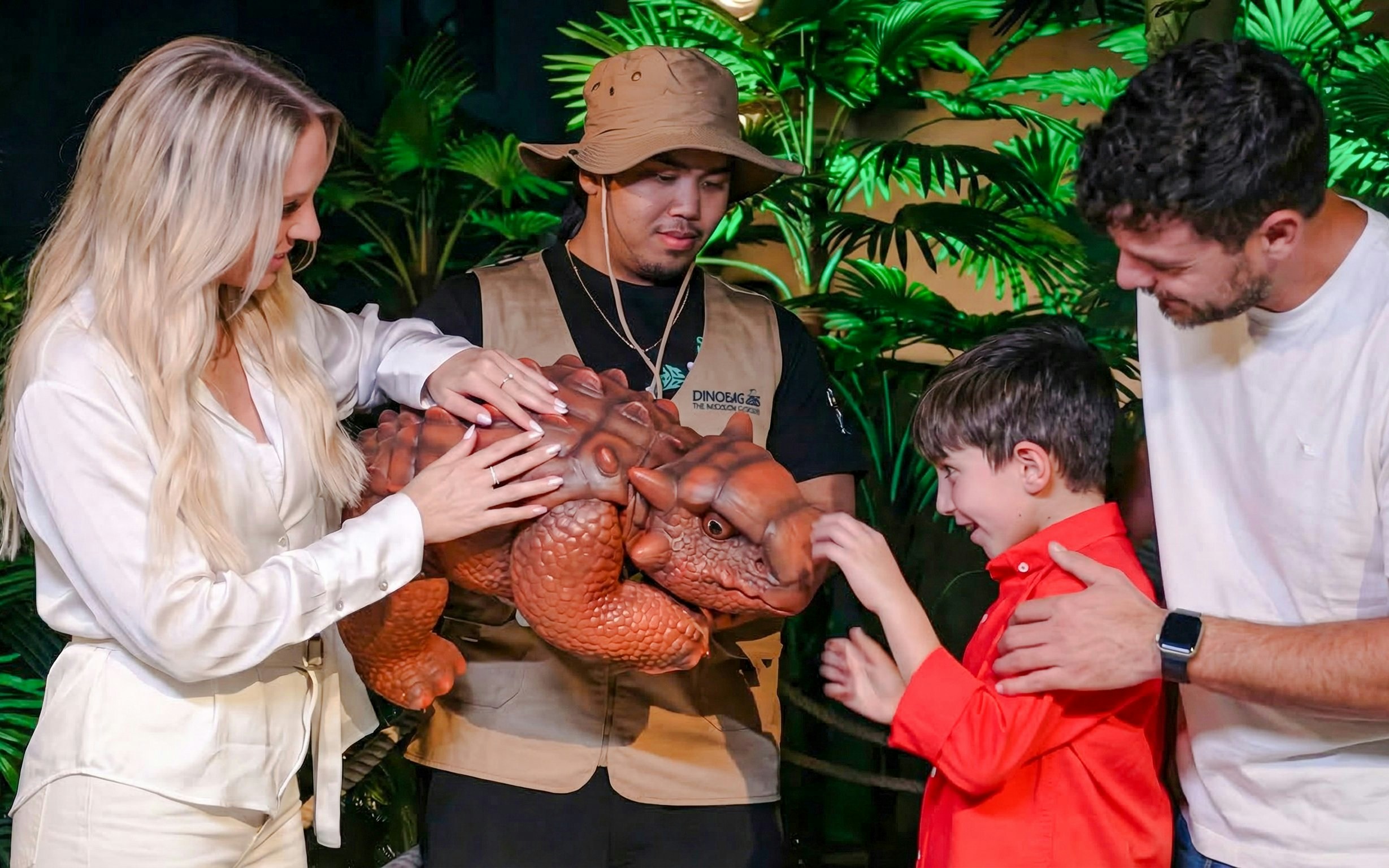 Visitors interacting with a dinosaur model at Dinosaurs: The Immersive Odyssey VR Experience.