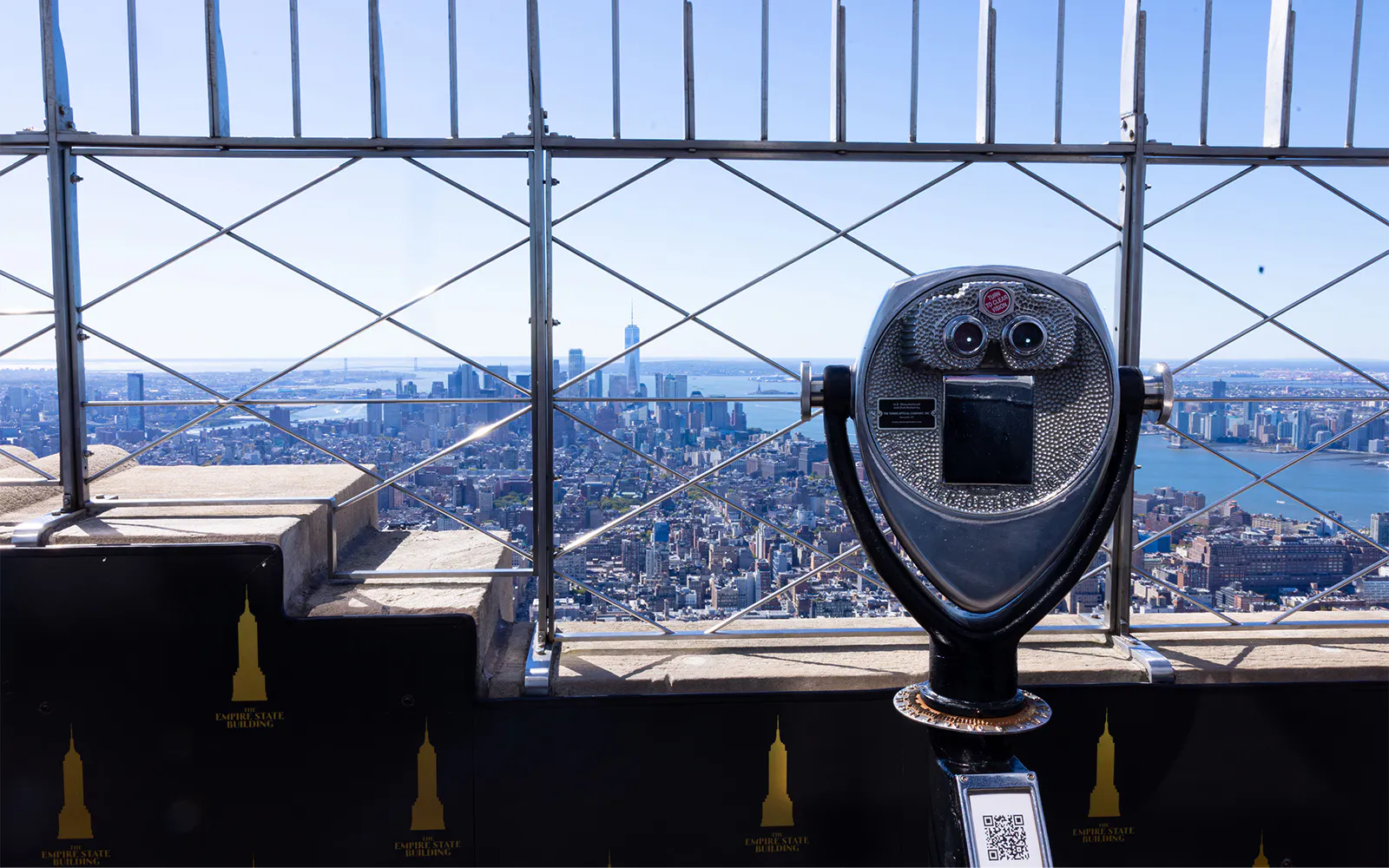 Observation deck view from Empire State Building overlooking New York City skyline.