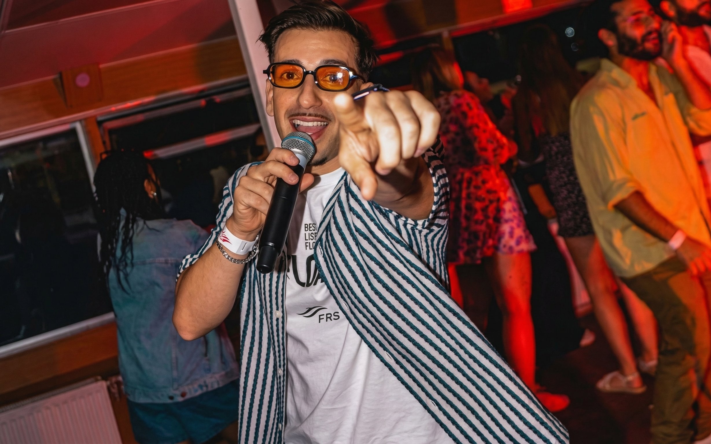 DJ performing on Lisbon Sunset Party Cruise with guests dancing.