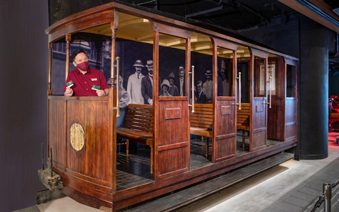 Tourist on The Peak Tram in Hong Kong holding tickets for Sky Terrace 428 experience.