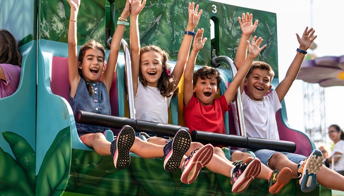 Tourists enjoying a thrilling ride at Isla Mágica amusement park in Seville, Spain, a highlight of the combo tour that includes a hop-on-hop-off city tour