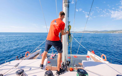 Crew member on catamaran during snorkeling cruise to Villefranche Bay.