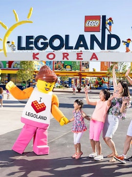 Family enjoying with Lego character at Legoland Korea Resort entrance.