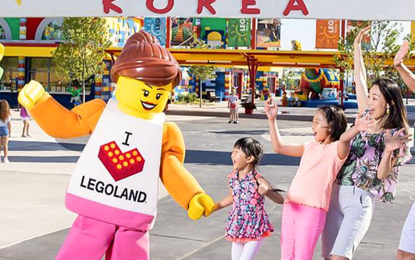 Family enjoying with Lego character at Legoland Korea Resort entrance.