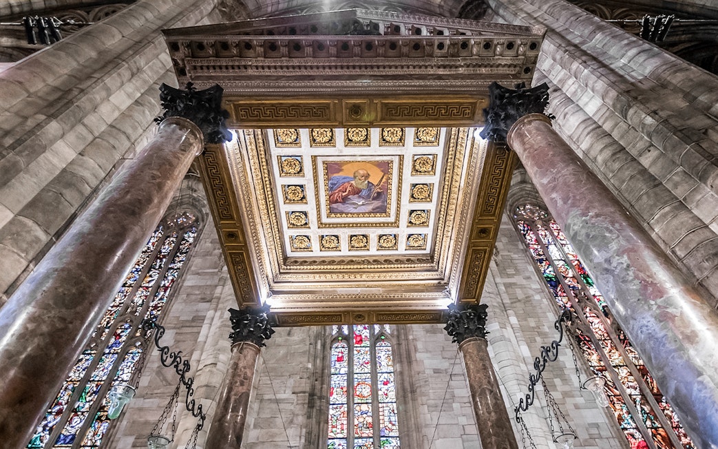 Ceiling and stained glass windows inside Duomo Cathedral, Milan.