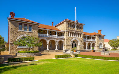 Historic building in Kings Park, Perth, with stone arches and manicured gardens.