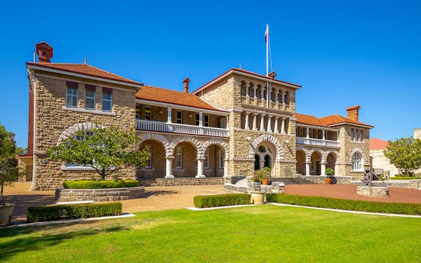 Historic building in Kings Park, Perth, with stone arches and manicured gardens.
