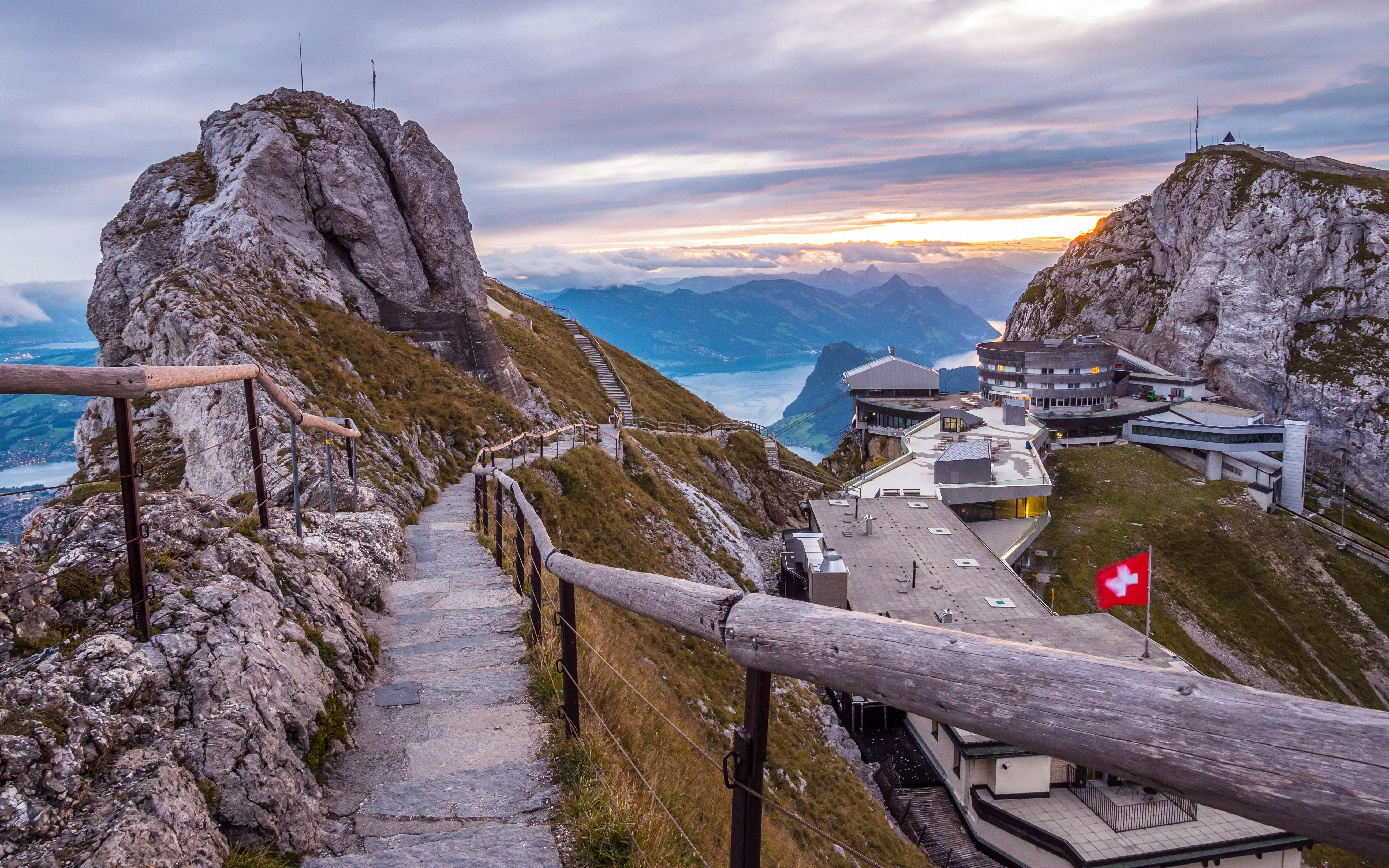 Summit of Pilatus Kulm in Switzerland with mountain path and buildings at sunrise.