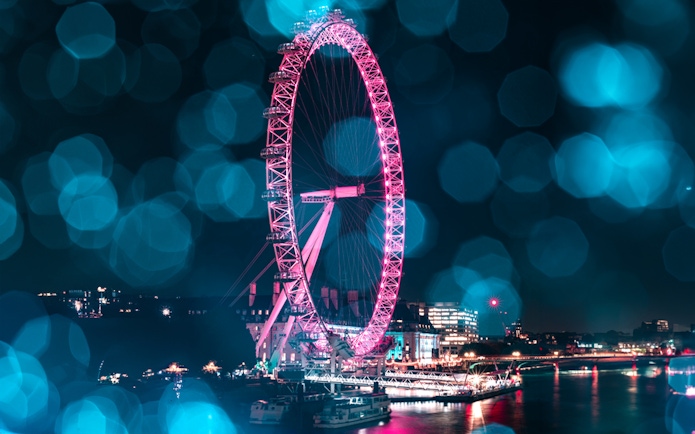 London Eye lit up at night during Christmas, viewed from the Thames, part of The Original Tour London 24Hr Pass.