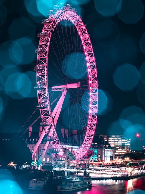 London Eye lit up at night during Christmas, viewed from the Thames, part of The Original Tour London 24Hr Pass.