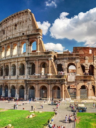Colosseum in Rome with tourists exploring the ancient amphitheater.