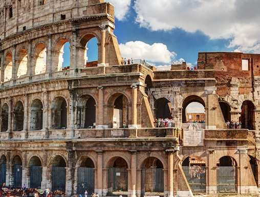 Colosseum in Rome with tourists exploring the ancient amphitheater.