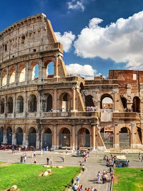 Colosseum in Rome with tourists exploring the ancient amphitheater.